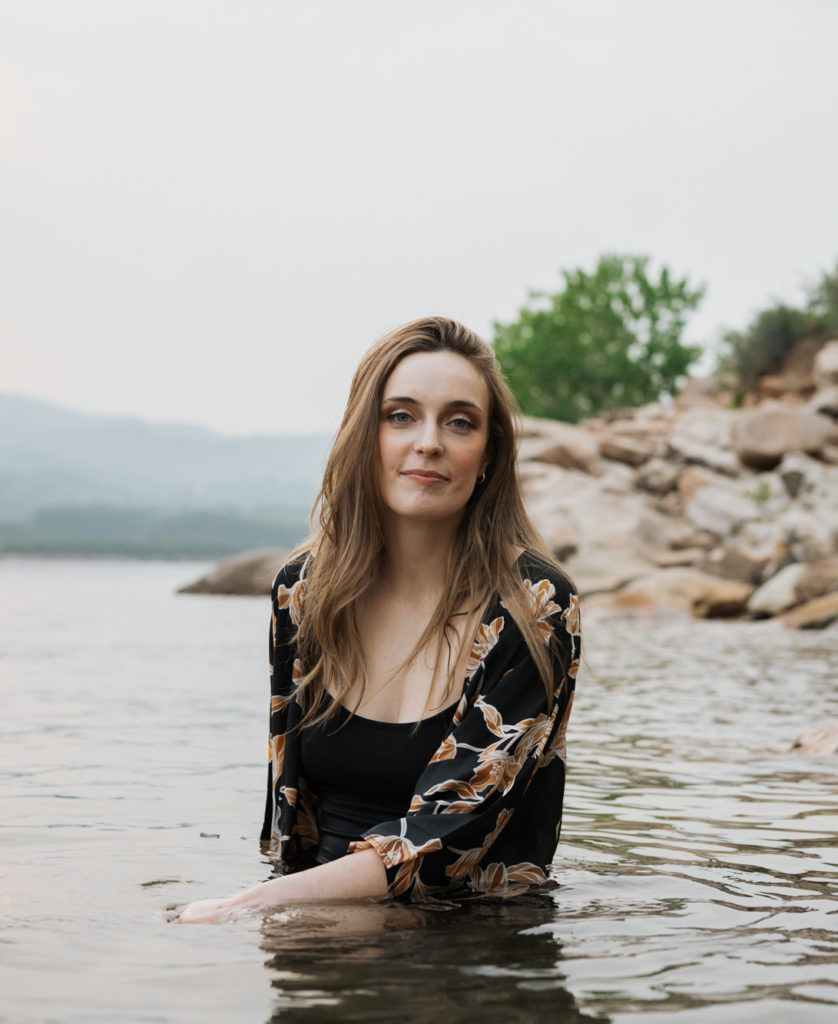 Woman smiles in a reservoir. Hire a professional book editor with Sirène Storyhouse.